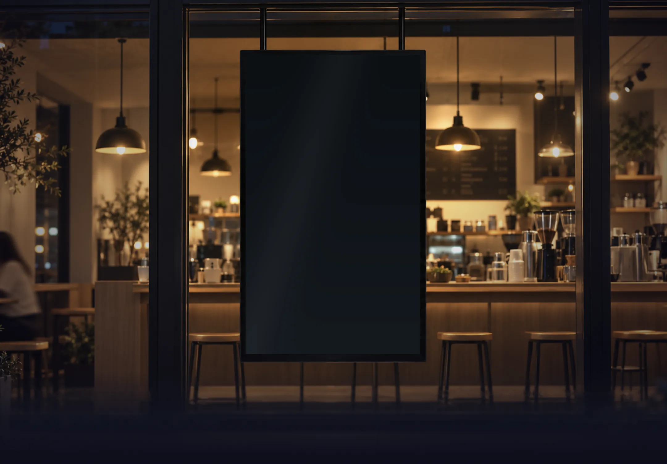 Café window at night with a hanging digital menu screen